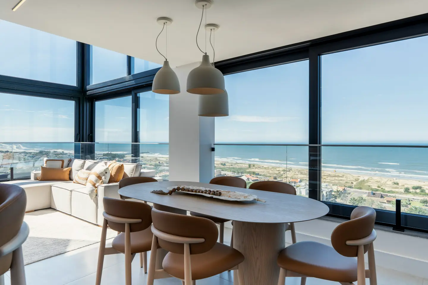 A glazed corner dining room above a long beach