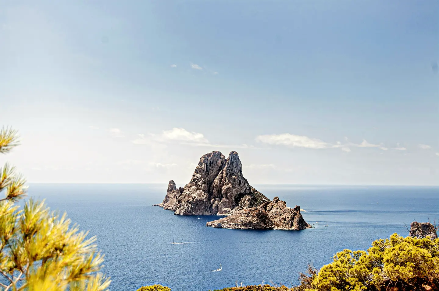 The rock of Es Vedra in the sea, seen through pines