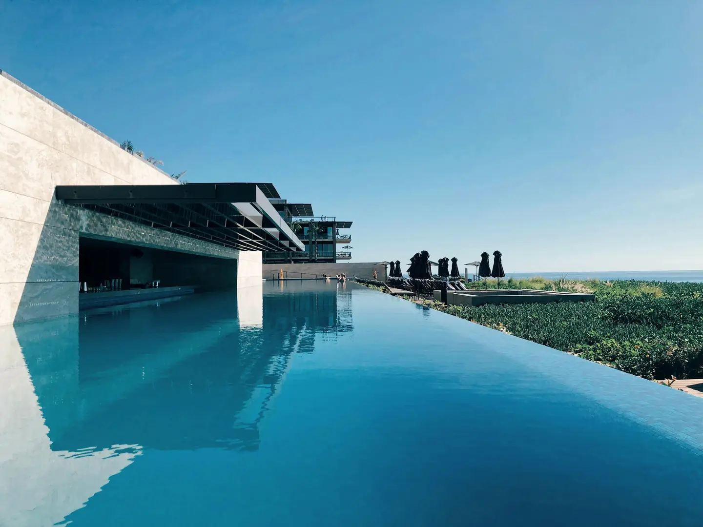 A long low house mirrored in still water, running out to the horizon