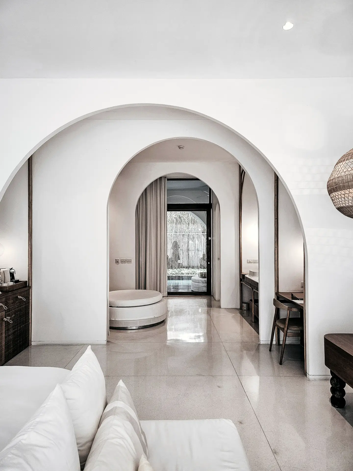 A white room seen through a sequence of arches
