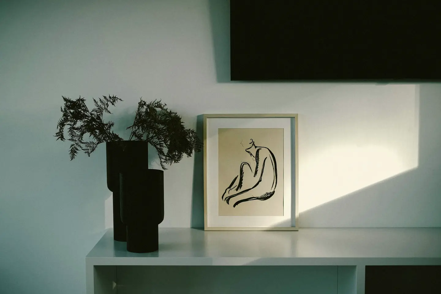 Late sun across a white living room open to a terrace